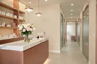 Intérieur d'un institut de beauté moderne et élégant dans le Val-de-Marne, avec un comptoir d'accueil fleuri et des produits de soin soigneusement disposés